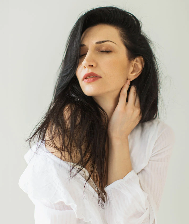 woman in white blouse touching neck | Ingram Cosmetic Surgery